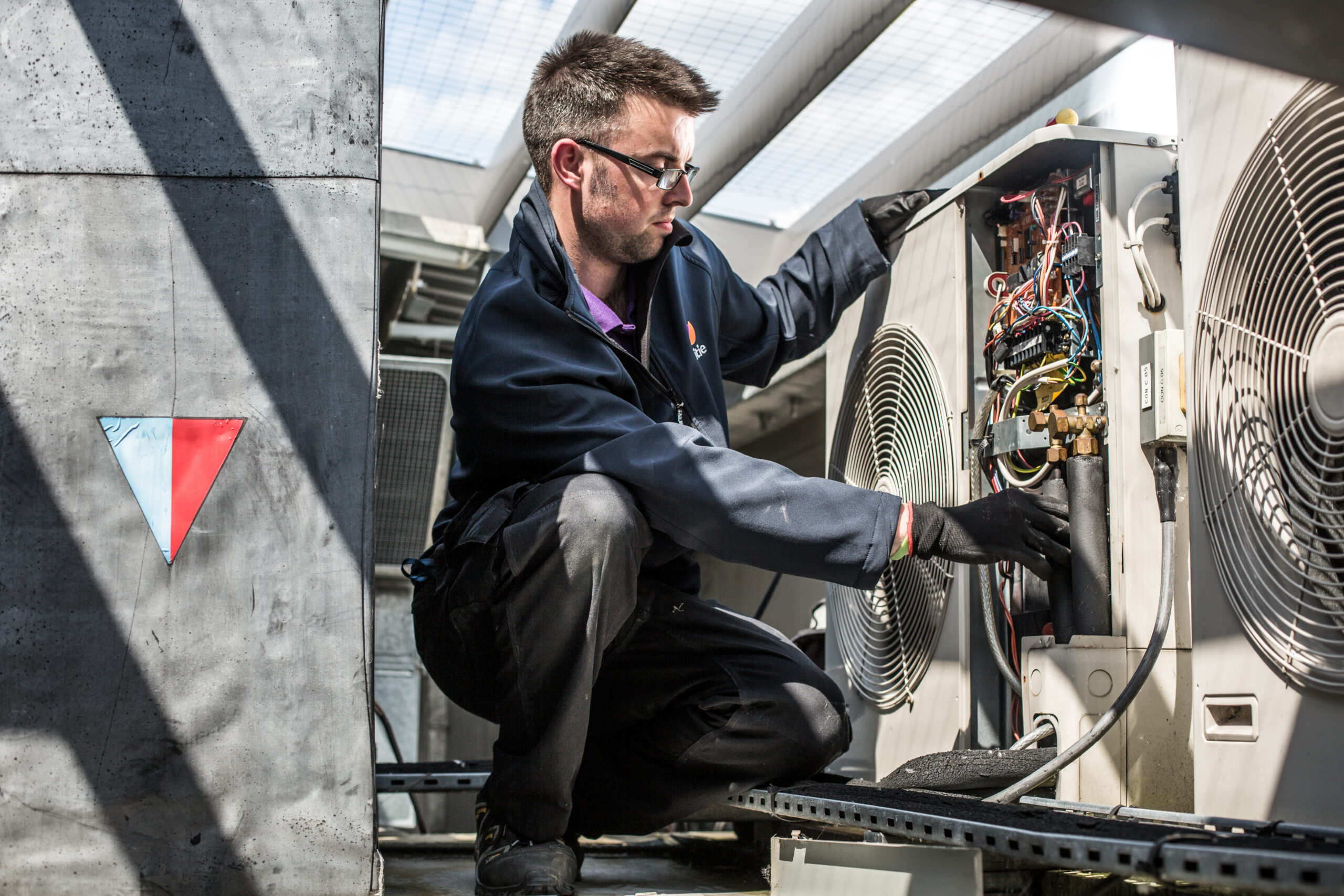 Mitie engineer fixing AC unit