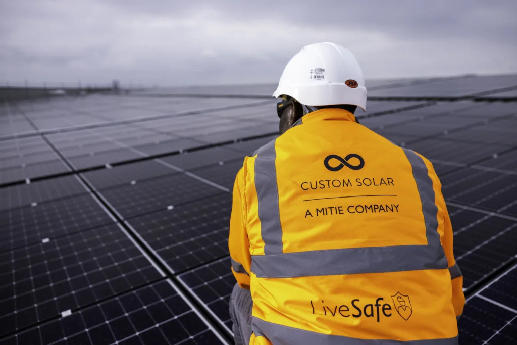 Custom Solar colleague looking at roof solar panels