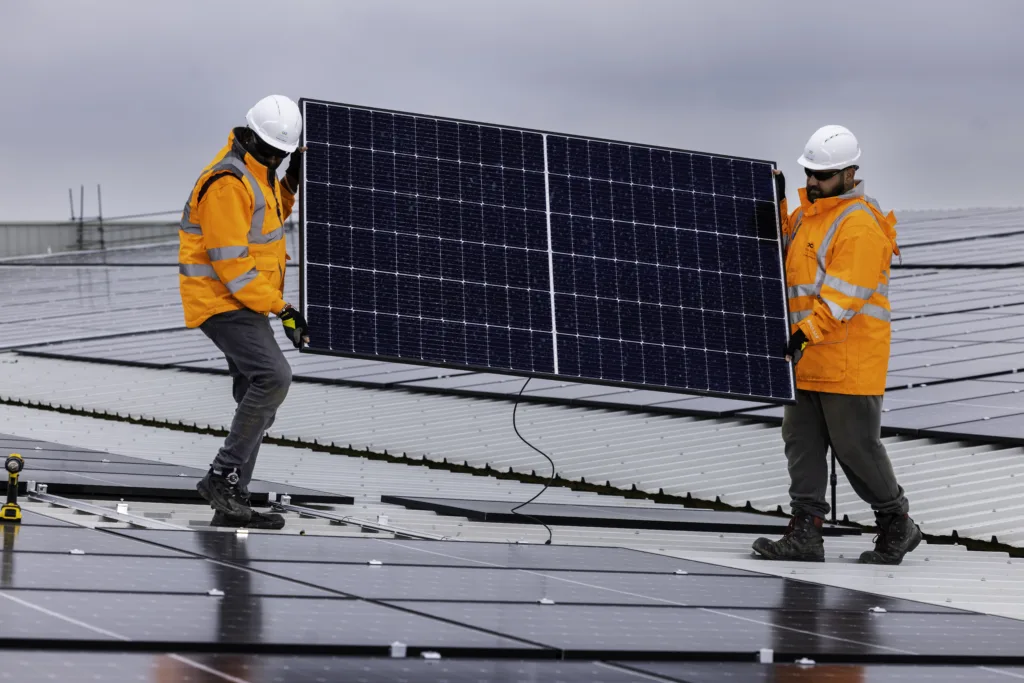 Custom Solar engineers carrying a solar panel