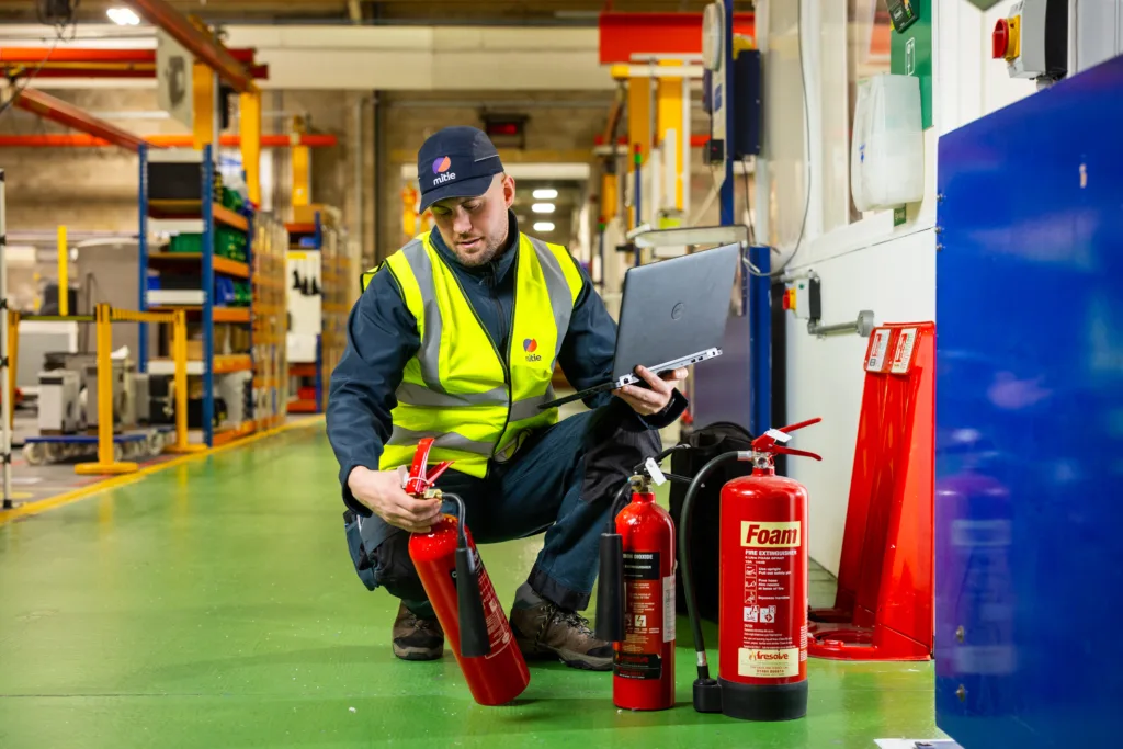 Mitie colleague checks fire extinguishers