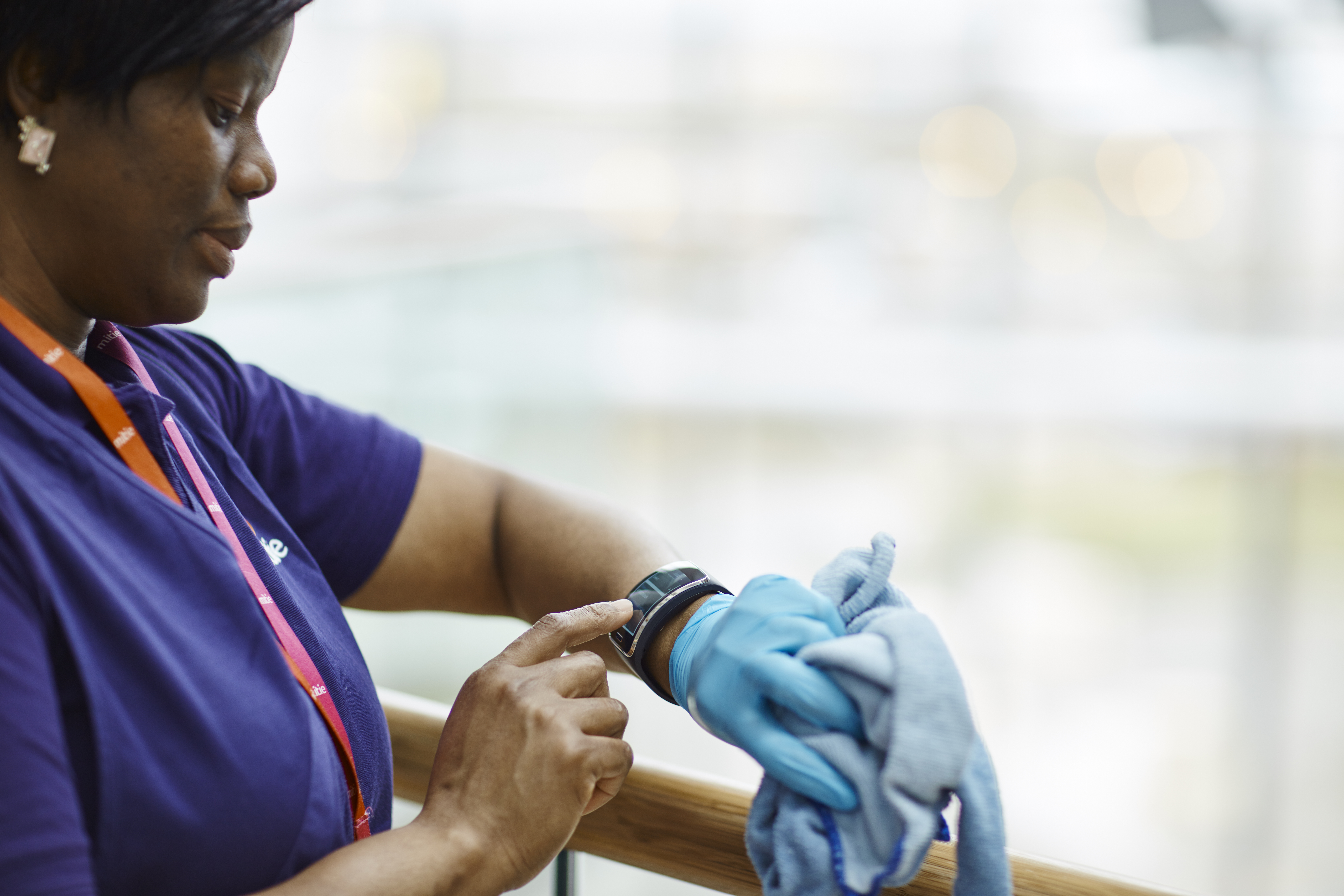 Mitie collegue checks her Merlin connect app