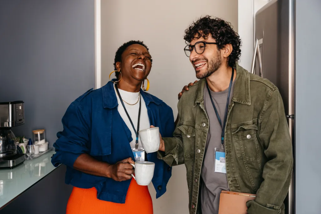 Two colleagues laughing over coffee