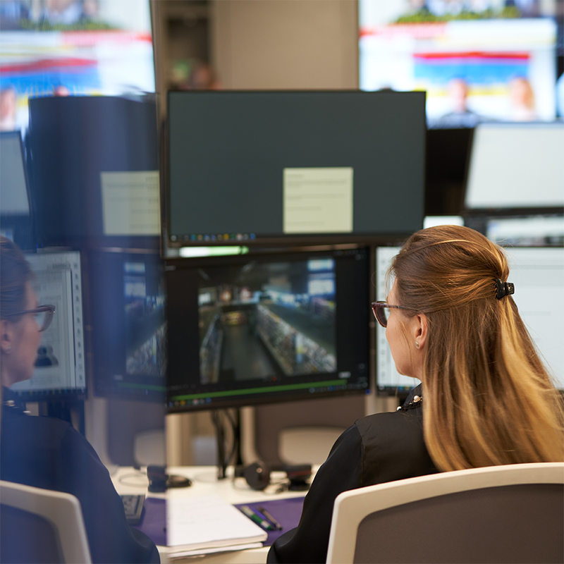 A female security officer examining surveillance footage
