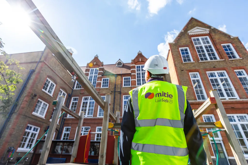 Mitie colleague looking up at a school building