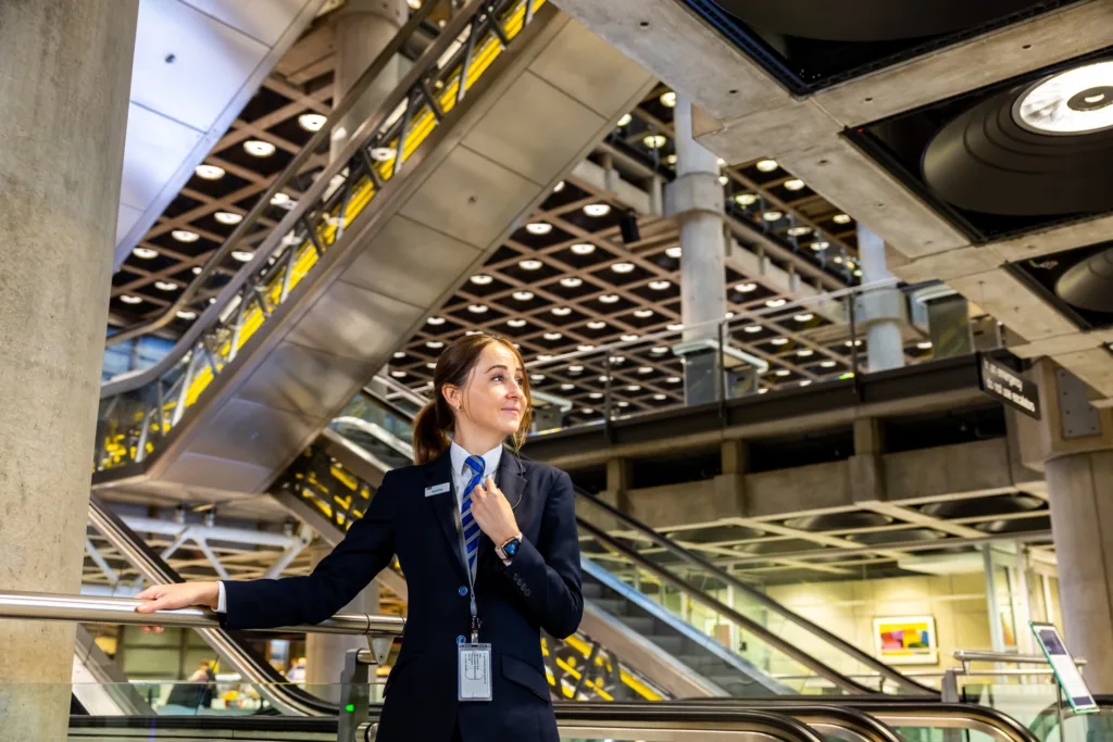 A security officer standing by an escalator