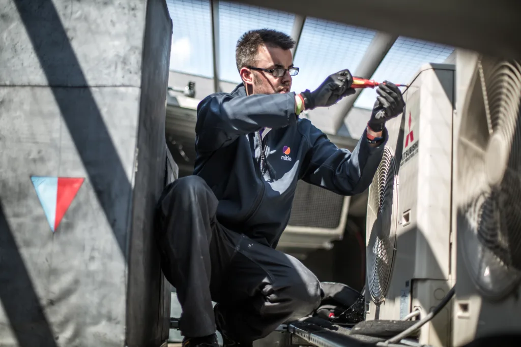 Male Mitie engineer fixing a fan