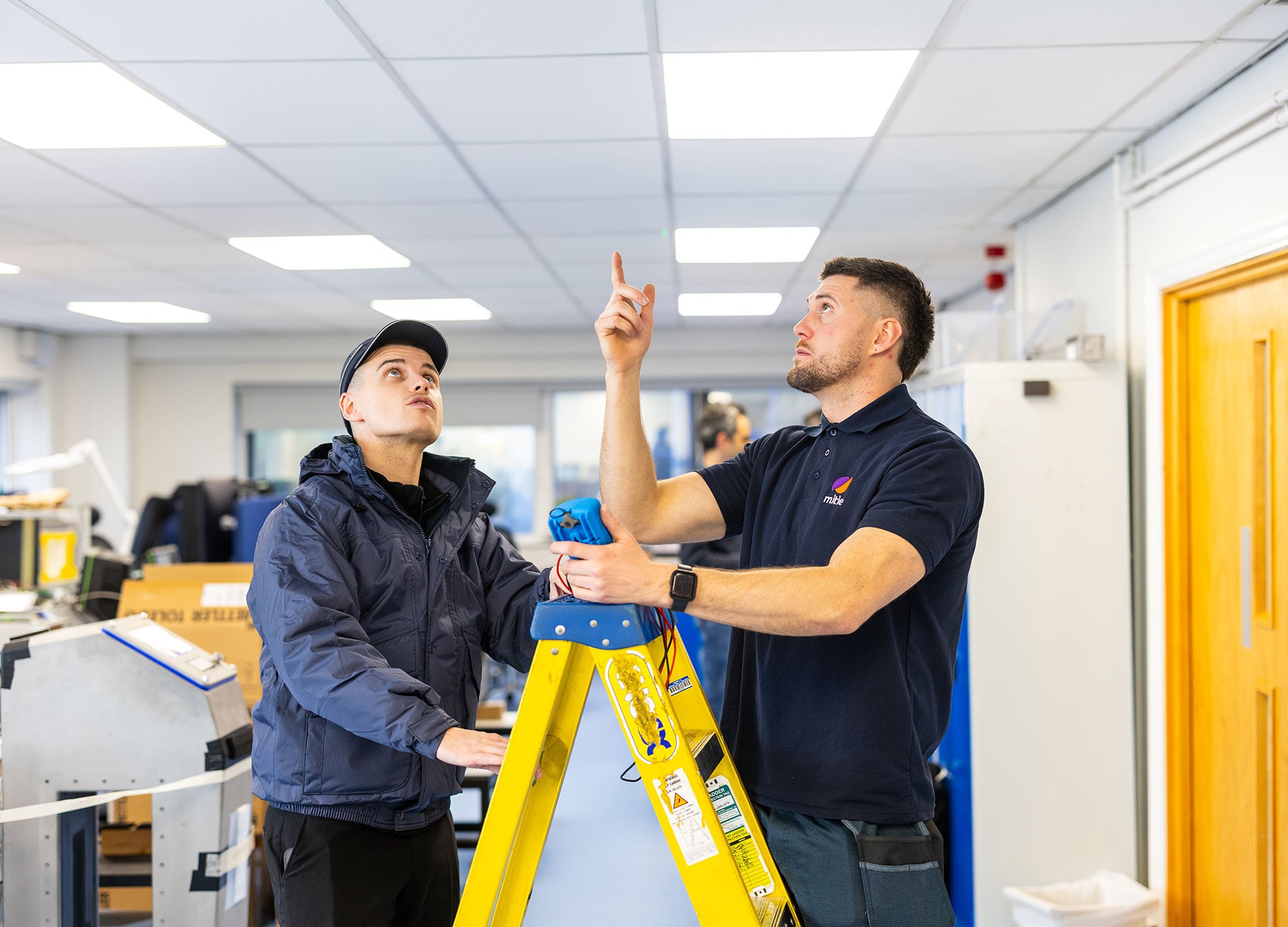 Mitie colleagues inspecting ceiling.