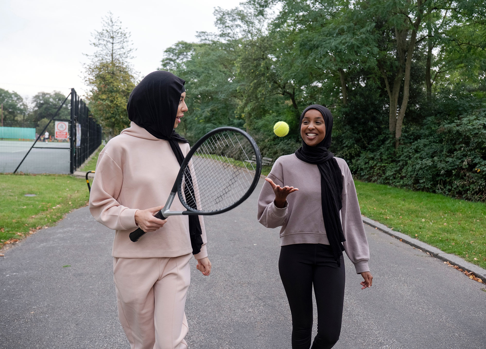 Girls playing tennis in the community.