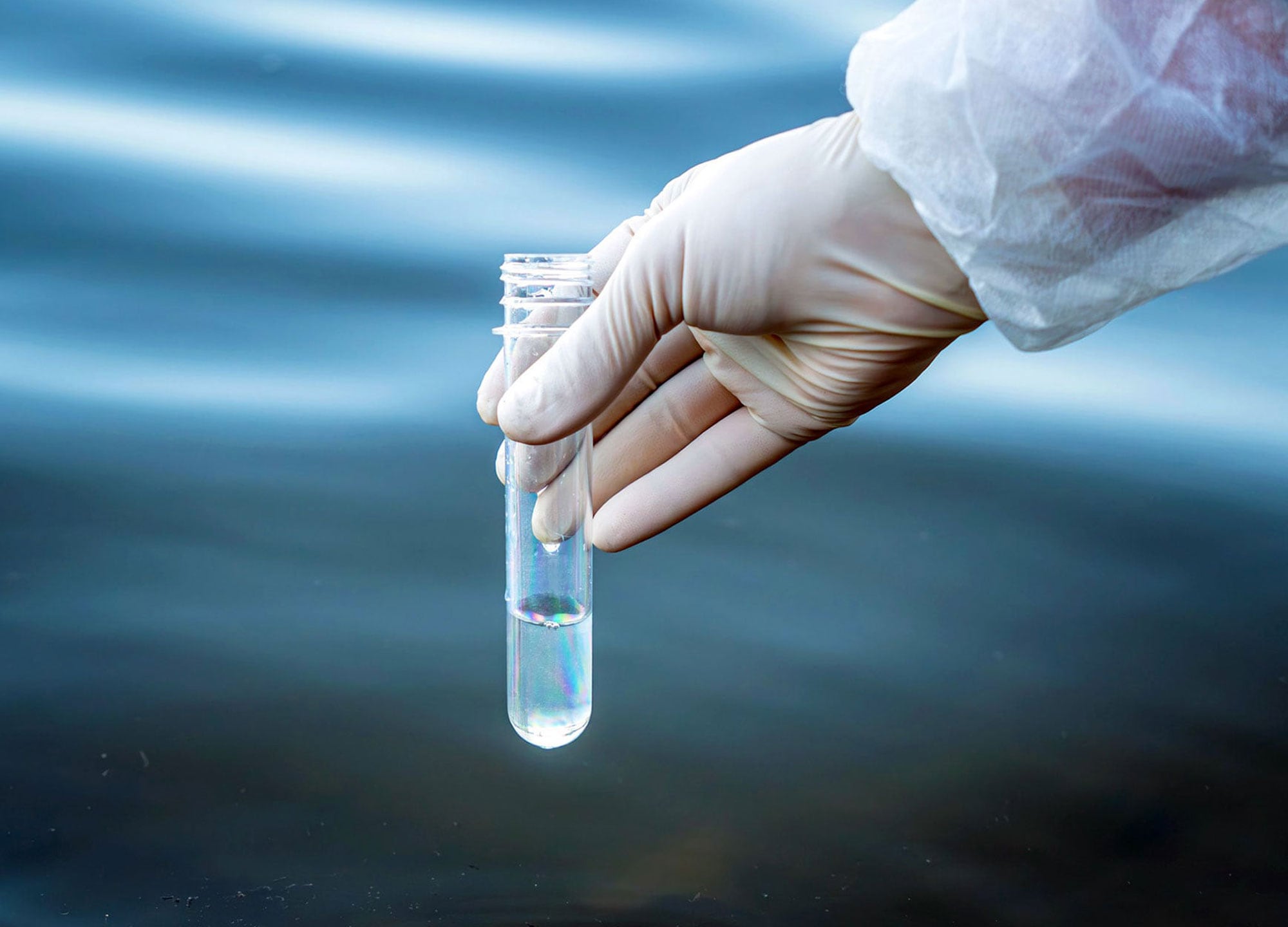 A hand holding a test tube full of water.