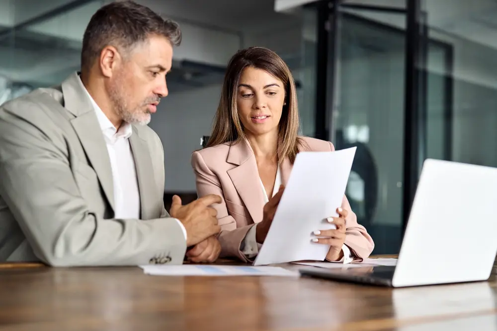 Two people looking at papers in an office meeting