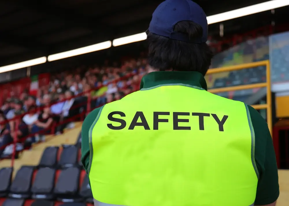 Safety officer at a stadium, facing the crowd