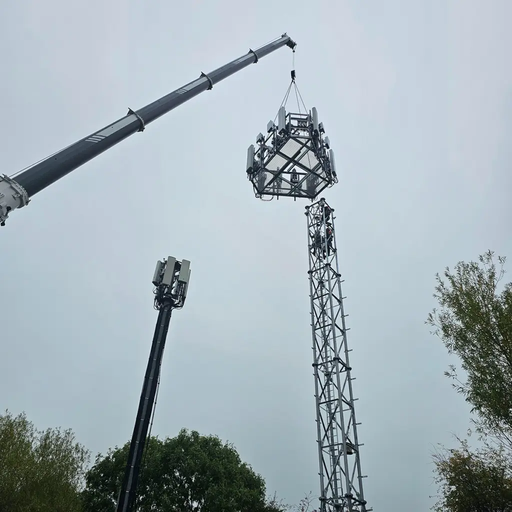 Crane lifting lights on top of a temporary tower